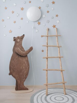 Whimsical nursery decor featuring a bear cutout, balloon, and star accents.